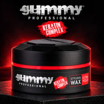 A black jar of Gummy Professional Keratin Complex Styling Wax Ultra Hold, set on a dark surface with dramatic red lighting and brand text overlays.
