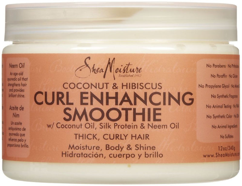 A jar of Shea Moisture Coconut Curl Enhancing Smoothie with the label detailing the addition of coconut oil, silk protein, and neem oil for moisture, body, and shine, specifically tailored for thick, curly hair.